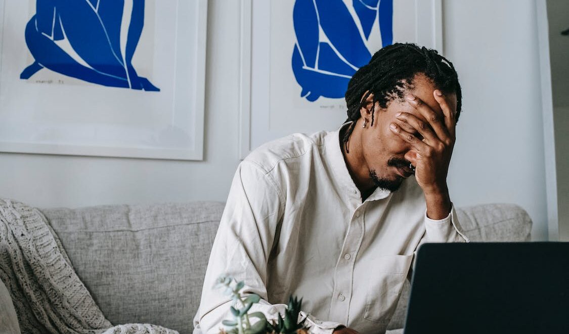 man holding his face