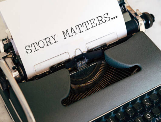 close up image of a vintage typewriter with paper sheet and the words story matters