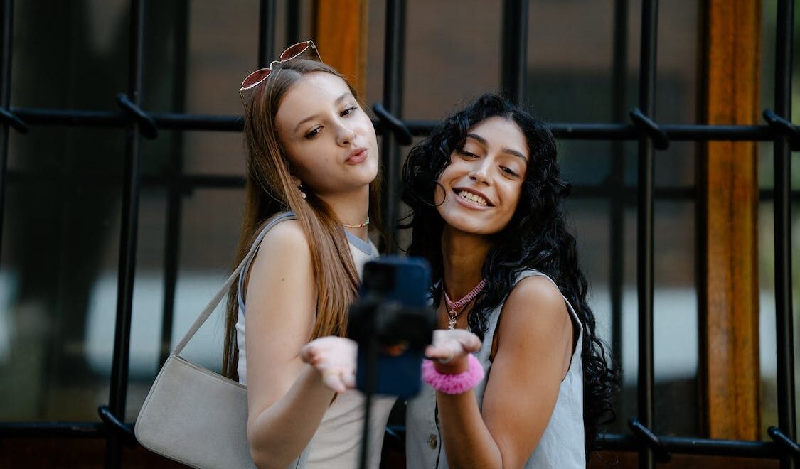 two girls taking a photo for content