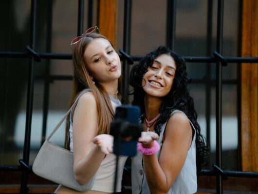 two girls taking a photo for content